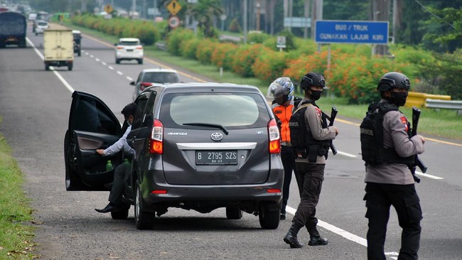 Petugas gabungan dari Polresta Bogor Kota, Dishub Kota Bogor dan Brimobda Jabar melakukan pemeriksaan kepatuhan penerapan Pembatasan Sosial Berskala Besar (PSBB) di pintu keluar gerbang tol Jagorawi, Kota Bogor, Jawa Barat, Senin (11/5/2020). Satlantas Polresta Bogor Kota mencatat sedikitnya 1.859 kasus pelanggaran selama penerapan PSBB Kota Bogor dalam tiga pekan terakhir diantaranya pelanggaran tanpa menggunakan masker selama berkendara, pengemudi kendaraan roda empat atau lebih yang mengangkut penumpang lebih dari 50 persen dan tidak menjalankan aturan physical distancing di dalam kendaraan. ANTARA FOTO/Arif Firmansyah/hp.