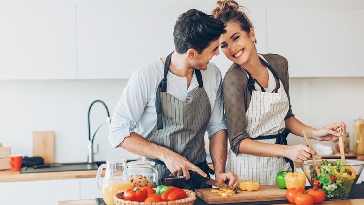 Lovely couple with fresh fruits and vegetables in the kitchen.