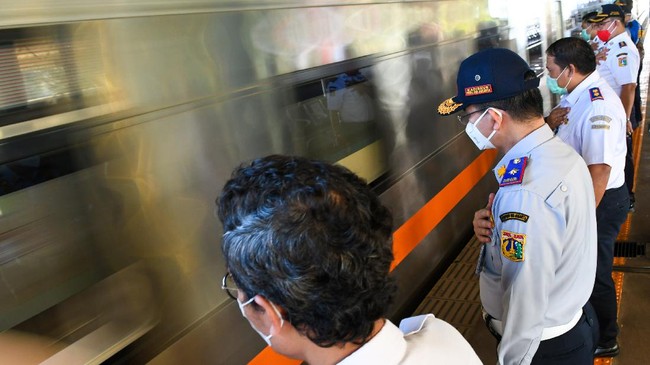 Sejumlah petugas Dinas Perhubungan DKI Jakarta beserta petugas PT Kereta Api Indonesia (KAI) memberi salam pada rangkaian kereta api luar biasa relasi Gambir-Surabaya Pasar Turi lintas selatan yang berangkat di Stasiun Gambir, Jakarta, Selasa (12/5/2020). PT Kereta Api Indonesia (KAI) mengoperasikan kereta api luar biasa (KLB) jarak jauh untuk melayani penumpang yang dikecualikan sesuai aturan pemerintah dengan penerapan protokol pencegahan COVID-19 yang ketat hingga 31 Mei 2020 mendatang. ANTARA FOTO/M Risyal Hidayat/foc.