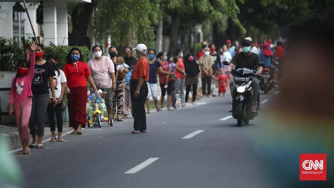 Warga antre mengambil takjil yang disediakan pengurus RT 005 RW 006 kawasan Cempaka Putih Raya,Jakarta, Selasa, 12 Mei 2020. CNNIndonesia/Safir Makki