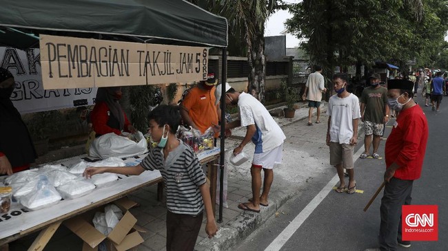 Warga antre mengambil takjil yang disediakan pengurus RT 005 RW 006 kawasan Cempaka Putih Raya,Jakarta, Selasa, 12 Mei 2020. CNNIndonesia/Safir Makki