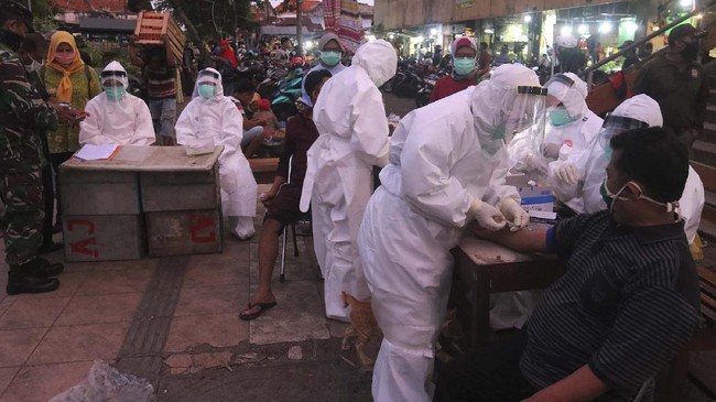 Petugas melakukan pemeriksaan cepat COVID-19 (Rapid Test) terhadap warga di Pasar Keputran, Surabaya, Jawa Timur, Selasa (12/5/2020). Pemeriksaan cepat terhadap sejumlah  pedagang dan buruh di pasar induk itu guna mengetahui kondisi kesehatan mereka serta untuk mencegah penyebaran virus Corona (COVID-19). ANTARA FOTO/Didik Suhartono/hp.