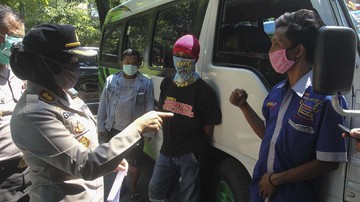 Polisi memeriksa sopir mikrobus yang mengangkut pemudik di Surabaya, Jawa Timur, Rabu (13/5/2020). Pemudik dengan jasa travel yang melanggar larangan mudik itu didata dan selanjutnya dipulangkan ke tempat asal sedangkan tujuh kendaraan mikrobus dari jasa travelnya dilakukan penindakan tilang. ANTARA FOTO/Didik Suhartono/foc.