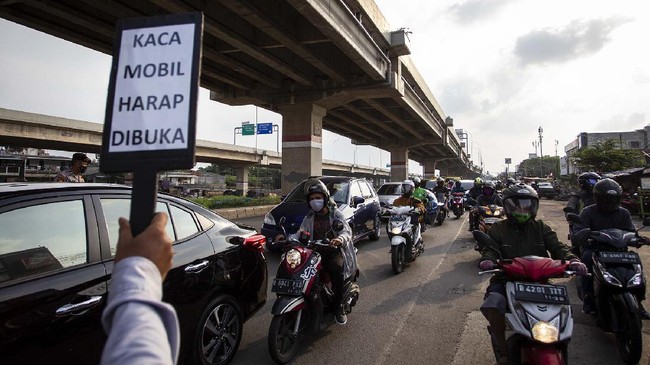 Petugas melakukan pengawasan terhadap kendaraan yang melintasi Check Point Pembatasan Sosial Berskala Besar (PSBB) di kawasan Kalimalang, Bekasi, Jawa Barat, Rabu (13/5/2020). Dalam pengawasan tersebut petugas menghimbau masyarakat untuk menggunakan masker saat berpergian dan mengatur posisi duduk serta pembatasan penumpang untuk kendaraan pribadi maupun angkutan umum. ANTARA FOTO/Dhemas Reviyanto/foc.