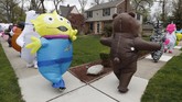 Parade Kostum Hiburan Ditengah Pandemi Corona In this Monday, May 11, 2020 photo, members of the T-Rex Walking Club walk through a neighborhood in Ferndale, Mich. While the club members get a kick out of their strolls through town, the idea is to bring a little bit of cheer to their fellow residents who remain under quarantine as part of Gov. Gretchen Whitmer’s stay-at-home order due to the COVID-19 pandemic. (AP Photo/Carlos Osorio)