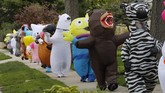 Parade Kostum Hiburan Ditengah Pandemi Corona In this Monday, May 11, 2020 photo, members of the T-Rex Walking Club walk through a neighborhood in Ferndale, Mich. While the club members get a kick out of their strolls through town, the idea is to bring a little bit of cheer to their fellow residents who remain under quarantine as part of Gov. Gretchen Whitmer’s stay-at-home order due to the COVID-19 pandemic. (AP Photo/Carlos Osorio)