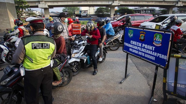 Petugas melakukan pengawasan terhadap kendaraan yang melintasi Check Point Pembatasan Sosial Berskala Besar (PSBB) di kawasan Kalimalang, Bekasi, Jawa Barat, Rabu (13/5/2020). Dalam pengawasan tersebut petugas menghimbau masyarakat untuk menggunakan masker saat berpergian dan mengatur posisi duduk serta pembatasan penumpang untuk kendaraan pribadi maupun angkutan umum. ANTARA FOTO/Dhemas Reviyanto/foc.