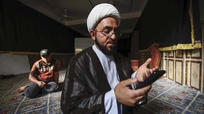 Shiite cleric Ali al-Atabi prays in the vicinity of Imam Ali shrine in Iraq's central holy city of Najaf during the Muslim holy fasting month of Ramadan, on May 11, 2020. - The spread of the coronavirus in Iraq prompted the major mosques to close to visitors, including the ornate burial place of Ali, the fourth Islamic caliph and relative of the Prophet Mohammed, in the shrine city Najaf, despite most shrines having remained open during the bloodiest years of Iraq's sectarian violence. But over the years, the shrines have developed several modern ways to experience a centuries-old tradition, with television channels airing round-the-clock images from the mausoleums, and a hotline providing free audio guides to the site. (Photo by Haidar HAMDANI / AFP)