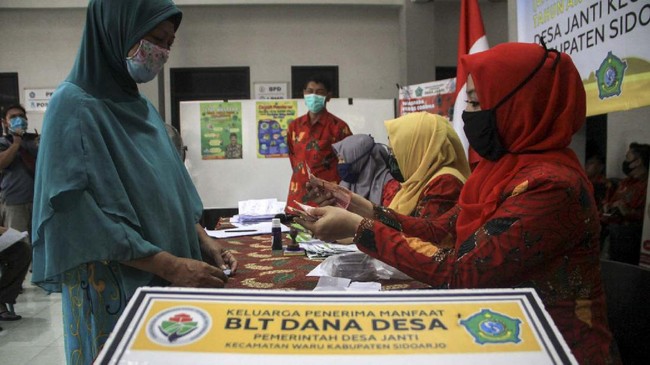 Warga saat menerima uang Bantuan Langsung Tunai (BLT) dana desa di Balai desa Janti, Waru, Sidoarjo, Jawa Timur, Kamis (14/5/2020). Bantuan langsung tunai (BLT) dari pemerintah melalui Kementerian Desa, Pembangunan Daerah Tertinggal, dan Transmigrasi  sebesar Rp600 ribu perbulan selama tiga bulan diberikan kepada warga miskin, orang sakit kronis bertahun-tahun, dan orang kehilangan pekerjaan karena pandemi Corona Virus Disease (COVID-19). ANTARA FOTO/Umarul Faruq/nz