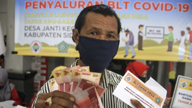 Warga saat menerima uang Bantuan Langsung Tunai (BLT) dana desa di Balai desa Janti, Waru, Sidoarjo, Jawa Timur, Kamis (14/5/2020). Bantuan langsung tunai (BLT) dari pemerintah melalui Kementerian Desa, Pembangunan Daerah Tertinggal, dan Transmigrasi  sebesar Rp600 ribu perbulan selama tiga bulan diberikan kepada warga miskin, orang sakit kronis bertahun-tahun, dan orang kehilangan pekerjaan karena pandemi Corona Virus Disease (COVID-19). ANTARA FOTO/Umarul Faruq/nz