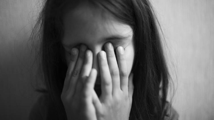 Little girl covers her face with hands isolated