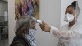 Dokter Gigi di Prancis Kembali Buka In this Wednesday, May 13, 2020 photo, a masked unidentified patient has her temperature checked by dental assistant Margot Daussat prior to a dental appointment at a dental office in Paris. Those with toothache that suffered through France's two-month lockdown, finally have hope to end the pain. Dental practices are cautiously re-opening and non-emergency dentist appointments are now permitted around the country, as the French government eased confinement restrictions from Monday. (AP Photo/Michel Euler)