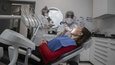 Dokter Gigi di Prancis Kembali Buka In this Wednesday, May 13, 2020 photo, dentist Sabrine Jendoubi, speaks to patient Veronique Guillot during a dental appointment, at a dental office in Paris. Those with toothache that suffered through France's two-month lockdown, finally have hope to end the pain. Dental practices are cautiously re-opening and non-emergency dentist appointments are now permitted around the country, as the French government eased confinement restrictions from Monday. (AP Photo/Michel Euler)
