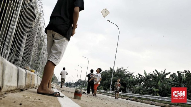 Anak-anak menerbangkan layang-layang di  sebuah lapangan di kawasan Cinere, Jakarta Selatan selama masa pandemi COVID-19 di Indonesia. Jakarta. Jumat (15/5/2020). CNNIndonesia/Andry Novelino