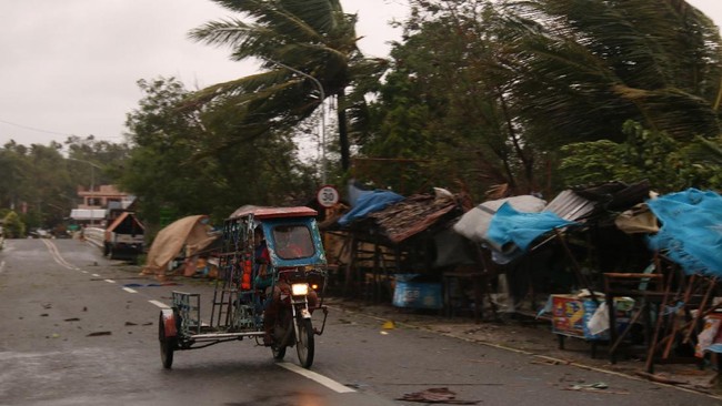A man drives his tricycle along a road as strong winds caused by typhoon Vongfong hit Catbalogan city, Western Samar province, eastern Philippines, Thursday May, 14, 2020. A strong typhoon slammed into the eastern Philippines on Thursday after authorities evacuated tens of thousands of people while trying to avoid the virus risks of overcrowding emergency shelters. (AP Photo/Simvale Sayat)