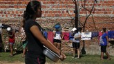 Paraguay Daratan yang People clutching containers wait in line for free lunch in the