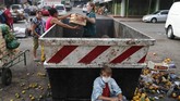 Paraguay Daratan yang With his family, Fabian Ramirez, 11, scavenges a trash container for discarded vegetables at the