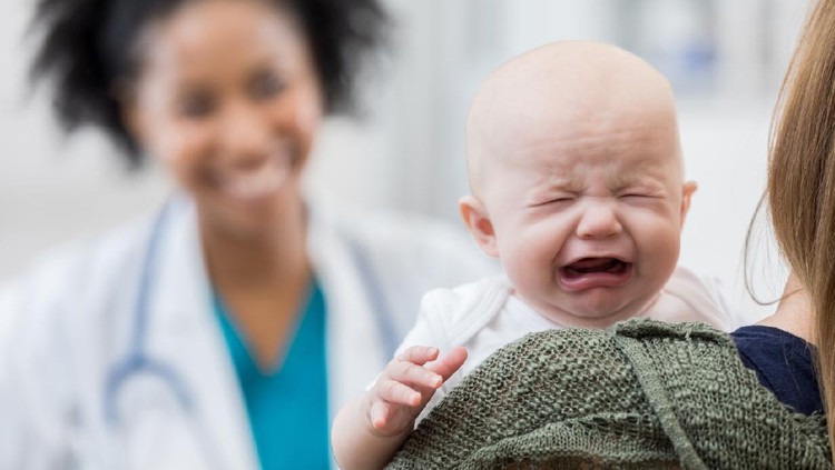 Upset Caucasian baby girl cries during well check appointment.