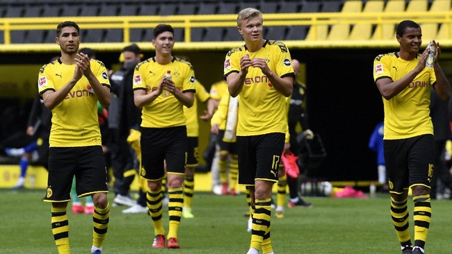 Dortmund's Erling Haaland, center, and his teammates celebrate at the end of the German Bundesliga soccer match between Borussia Dortmund and Schalke 04 in Dortmund, Germany, Saturday, May 16, 2020. The German Bundesliga becomes the world's first major soccer league to resume after a two-month suspension because of the coronavirus pandemic. Dortmund won 4-0. (AP Photo/Martin Meissner, Pool)