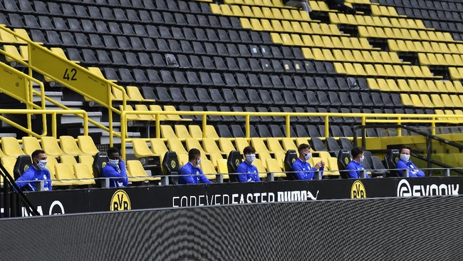 Schalke alternate players sit on the bench during the German Bundesliga soccer match between Borussia Dortmund and Schalke 04 in Dortmund, Germany, Saturday, May 16, 2020. The German Bundesliga becomes the world's first major soccer league to resume after a two-month suspension because of the coronavirus pandemic. (AP Photo/Martin Meissner, Pool)