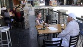 Restoran di Amerika Mulai Dibuka Kembali In this Thursday, May 14, 2020 photo, Sara Crane and James Hall, both of Henderson, dine outside at Hennessey's Tavern at the Fremont Street Experience in downtown Las Vegas. The business moved tables to the sidewalk in front of the restaurant after The City of Las Vegas temporarily allowed outdoor dining on public sidewalks. (K.M. Cannon/Las Vegas Review-Journal via AP)