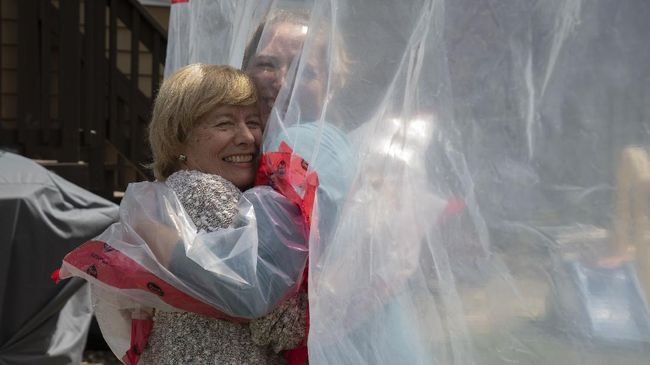 Hug Glove Carolyn Ellis (R) hugs her mother Susan Watts using the