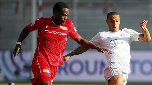 FC Union Berlin's Anthony Ujah in action with Bayern Munich's Thiago, right, during the German Bundesliga soccer match between Union Berlin and Bayern Munich in Berlin, Germany, Sunday, May 17, 2020. The German Bundesliga becomes the world's first major soccer league to resume after a two-month suspension because of the coronavirus pandemic. (AP Photo/Hannibal Hanschke, Pool)