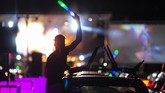 Disko Mobil di Jerman A man celebrates outside his car window during a car disco event playing house music in Altenburg, Germany, Saturday, May 16, 2020. Due to the coronavirus pandemic, major events are restricted and the car disco is an alternative that people enjoy. Up to 250 cars are allowed on the premises and people can celebrate until 1 a.m. (AP Photo/Jens Meyer)