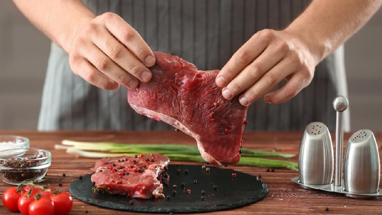 Ilustrasi daging Man preparing meat in kitchen