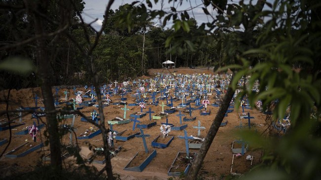In this May 11, 2020 photo, graves for people who have died in the past month fill a new section of the Nossa Senhora Aparecida cemetery, amid the new coronavirus pandemic, in Manaus, Brazil. Indigenous tribes dwelling up the Solimoes and Negro rivers that merge in Manaus to form the Amazon River tried for weeks to seal their reserves off from the virus, pleading for donations while awaiting government delivery of food assistance so they could remain isolated. It didn't come for many, indigenous advocates said. (AP Photo/Felipe Dana)