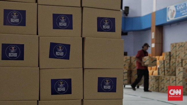 Relawan Gugus Tugas Percepatan Penanganan Covid-19 memindahkan kotak berisi sembako di GOR Gelanggang Remaja, Jakarta, Selasa (18/5/2020)