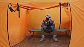 Bilik Isolasi Mandiri Untuk ODP A security guard wearing a protective mask sit inside an isolation tent that will serve as a quarantine facility for people showing symptoms of the COVID-19 at an indoor stadium prepared to become an emergency hospital amid the new coronavirus outbreak in Jakarta, Indonesia, Monday, May 18, 2020. (AP Photo/Tatan Syuflana)