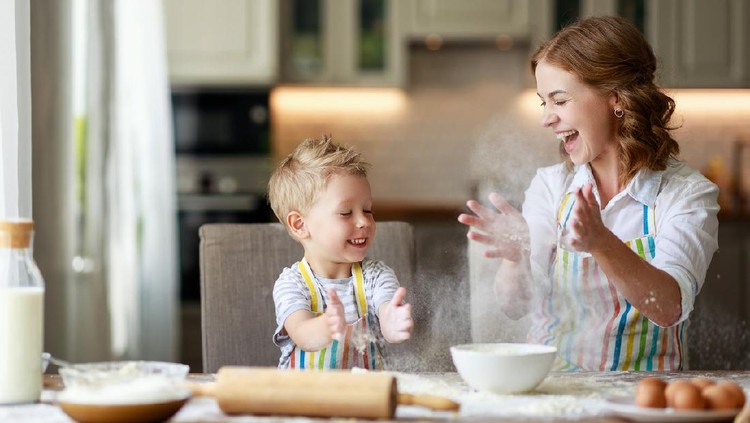 happy family in the kitchen. mother and  child son preparing the dough, bake cookies