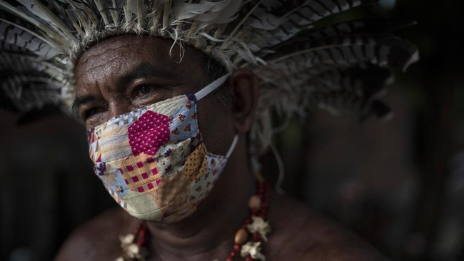 In this May 10, 2020 photo, Pedro dos Santos, the leader of a community named Park of Indigenous Nations, poses for a photo, in Manaus, Brazil. Manaus' lack of the new coronavirus treatment prompted Pedro dos Santos to drink tea made of chicory root, garlic and lime to combat a high fever that lasted 10 days. (AP Photo/Felipe Dana)