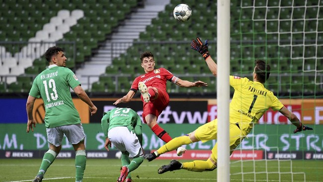 Leverkusen's Kai Havertz, center, scores the opening goal during the German Bundesliga soccer match between Werder Bremen and Bayer Leverkusen 04 in Bremen, Germany, Monday, May 18, 2020. The German Bundesliga becomes the world's first major soccer league to resume after a two-month suspension because of the coronavirus pandemic. (AP Photo/Stuart Franklin, Pool)