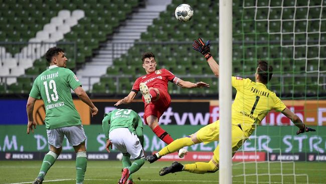 Leverkusen's Kai Havertz, center, scores the opening goal during the German Bundesliga soccer match between Werder Bremen and Bayer Leverkusen 04 in Bremen, Germany, Monday, May 18, 2020. The German Bundesliga becomes the world's first major soccer league to resume after a two-month suspension because of the coronavirus pandemic. (AP Photo/Stuart Franklin, Pool)