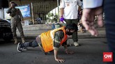 SANKSI BAGI PELANGGAR PSBB Seorang pelanggar Pembatasan Sosial Berskala Besar (PSBB) menerima sanksi push up di kawasan Terminal Kampung Melayu, Jakarta, Rabu, 20 Mei 2020. Sanksi kerja sosial seperti menyapu, menyiram tanaman sampai push-up diberlakukan bagi warga yang tak mengenakan masker saat beraktifitas di tempat umum. CNNIndonesia/Safir Makki
