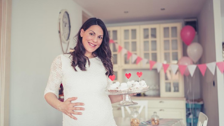 Pregnant woman welcoming gussets to her baby shower party