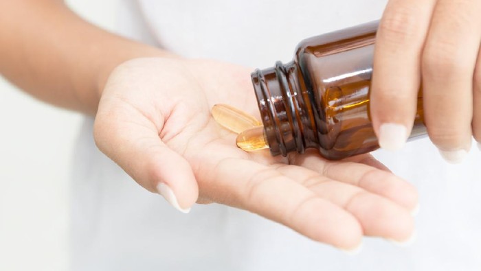 closeup hand holding fish oil vitamin for healthy