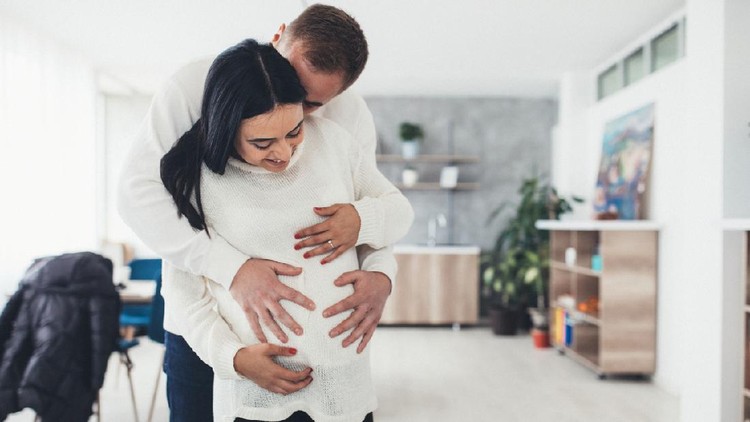 Young Asian husband touching/listening on belly pregnant wife with love and happy