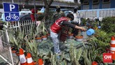 SANKSI BAGI PELANGGAR PSBB Seorang pelanggar Pembatasan Sosial Berskala Besar (PSBB) menerima sanksi menyiram tanaman di kawasan Terminal Kampung Melayu, Jakarta, Rabu, 20 Mei 2020. Sanksi kerja sosial seperti menyapu, menyiram tanaman sampai push-up diberlakukan bagi warga yang tak mengenakan masker saat beraktifitas di tempat umum. CNNIndonesia/Safir Makki