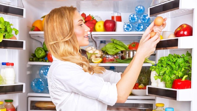 Cute female taking eggs from the fridge, attractive housewife take care about health, fresh tasty organic food, healthy eating concept