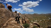 Wisata Taman Nasional Joshua Tree di California Matilda Fresk, left, and Enosh Baker hike along the rocks at Joshua Tree National Park in California, Tuesday, May 19, 2020. The park reopened this week after a lengthy closure to help slow the spread of the new coronavirus. (AP Photo/Jae C. Hong)