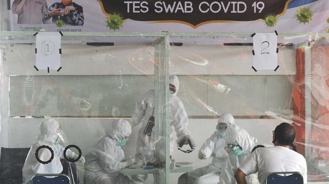 Petugas medis mengambil sampel lendir dari seorang pedagang saat tes swab di Pasar Raya Padang, Sumatera Barat, Rabu (20/5/2020). Pemkot Padang melakukan tes swab terhadap pedagang dan orang-orang yang terkait di pasar itu dengan target 1.000 orang, untuk memutus penyebaran COVID-19 di klaster Pasar Raya tersebut. ANTARA FOTO/Iggoy el Fitra/foc.