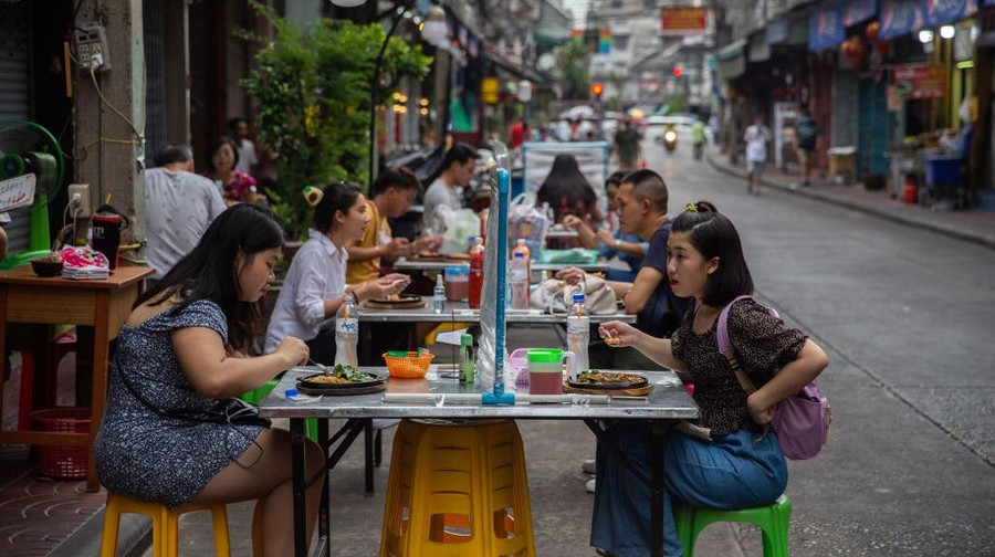 Rumah makan di Thailand telah diizinkan buka kembali. Kini rumah makan buka dengan menerapkan jaga jarak dan pembatas plastik, seperti terlihat di Chinatown.