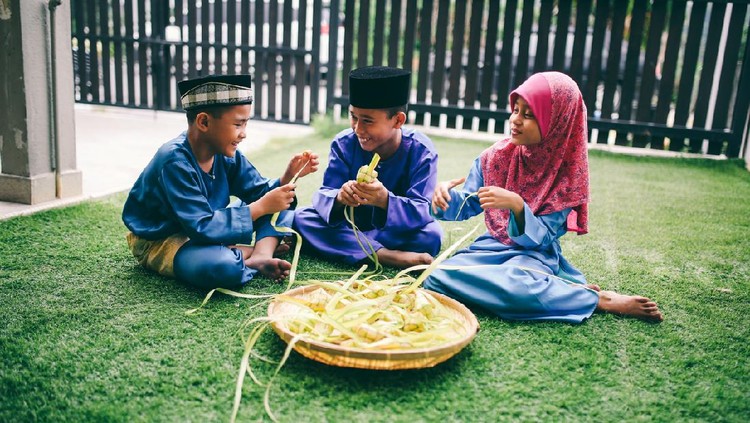 Siblings preparing food in front of house during eid celebration in Malaysia