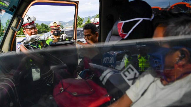 Petugas Polresta Cirebon memeriksa kendaraan yang melintas di pintu Tol Cipali Palimanan, Cirebon, Jawa Barat, Kamis (21/5/2020). Pemeriksaan tersebut sebagai upaya penyekatan gelombang pemudik jelang perayaan Hari Raya Idul Fitri 1441 H dari arah Jakarta menuju Jawa Tengah. ANTARA FOTO/Nova Wahyudi/nz