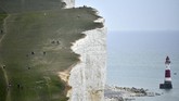 Nyalang Edisi 23 Mei 2020 People walk along the cliff-top above the lighthouse at Beachy Head near Eastbourne on the south coast of England on May 17, 2020, following an easing of lockdown rules in England during the novel coronavirus COVID-19 pandemic. - People are being asked to