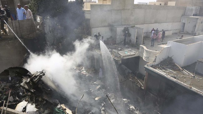 Fire brigade staff try to put out fire caused by plane crash in Karachi, Pakistan, Friday, May 22, 2020. An aviation official says a passenger plane belonging to state-run Pakistan International Airlines carrying more than 100 passengers and crew has crashed near the southern port city of Karachi. There were no immediate reports on the number of casualties. (AP Photo/Fareed Khan)