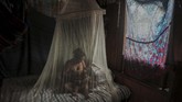 Nyalang Edisi 23 Mei 2020 Satere-Mawe indigenous mother Priscila Tavares Batista, 36 breastfeeds her son Jone Tavares, 2, in a bed protected by a mosquito net, after being treated with medicinal herbs after showing symptoms of COVID-19, in the Wakiru community, in Taruma neighbourhood, a rural area west of Manaus, Amazonas State, Brazil, on May 17, 2020, during the novel coronavirus pandemic. - According to Satere-Mawe indigenous leader Andre Satere, eleven people in their community are showing COVID-19 symptoms. The local and state governments were called to assist to no avail. With the Amazonas state health system saturated, indigenous people turn to their ancestral knowledge about the region's nature to stay healthy and treat possible symptoms of the novel coronavirus. (Photo by Ricardo OLIVEIRA / AFP)